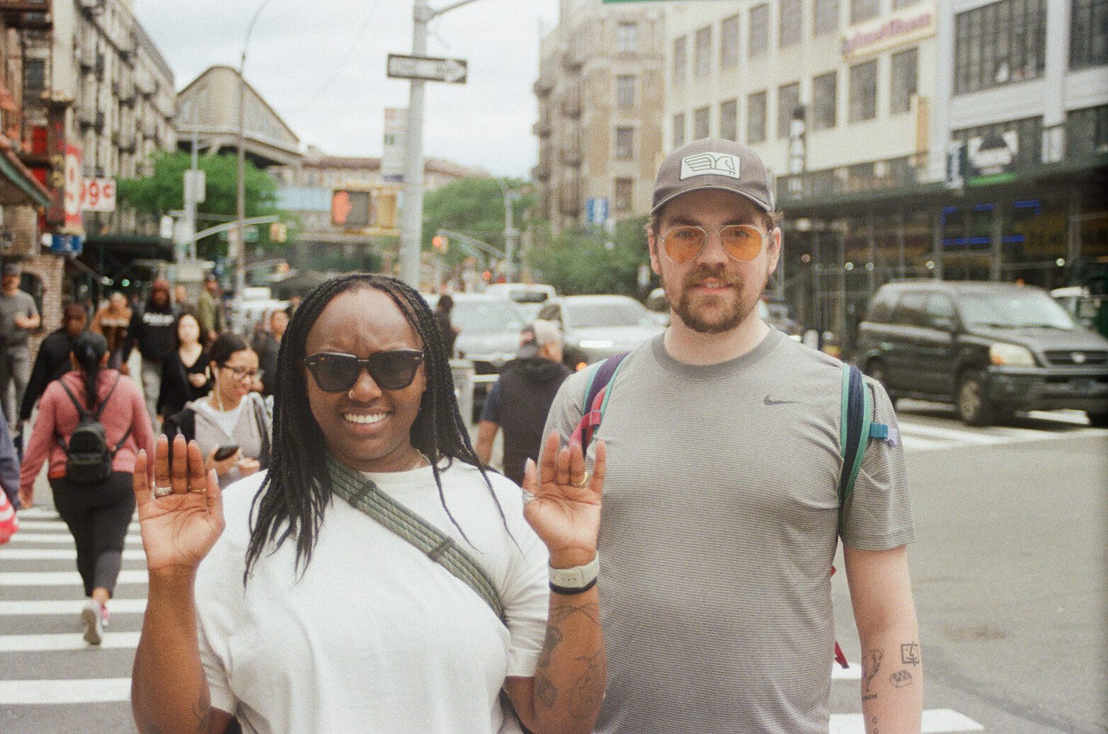 Robin and Pierce waving at the camera on a city street