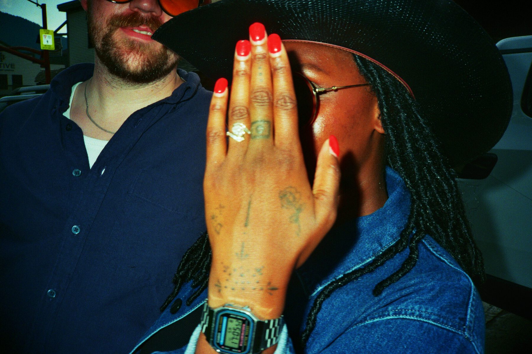 Robin hiding her face behind her ring hand while Pierce laughs beside her